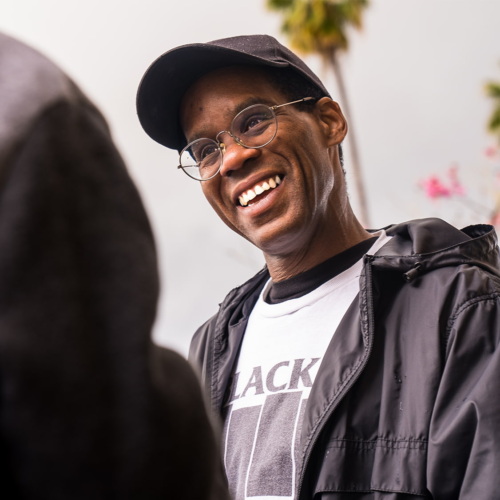 A man smiles in conversation with someone.