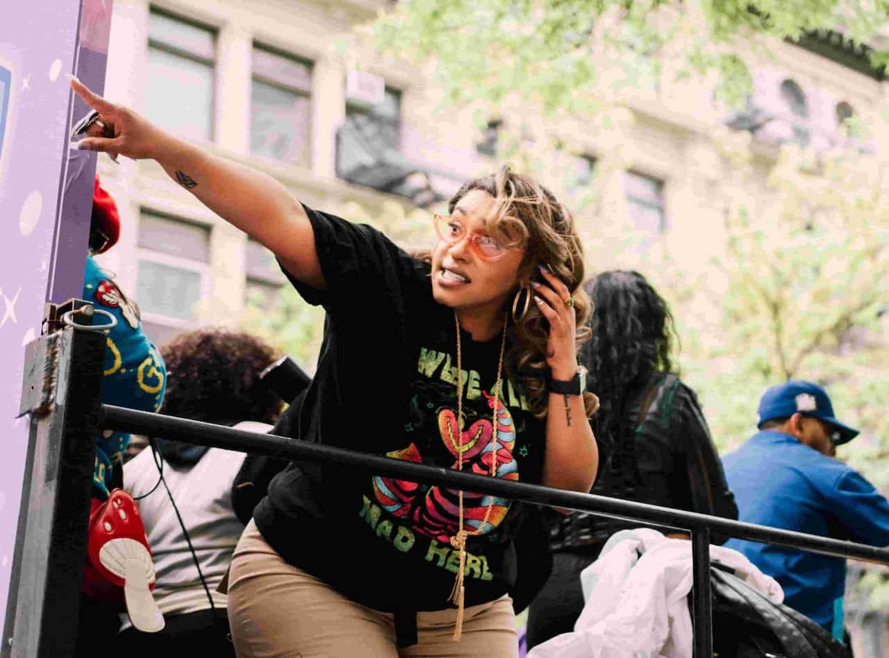 Photo of a woman pointing to the left while on a parade float.