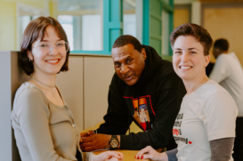 Photo of three people, two women on the right and left and a man in the center. They are in an office setting.